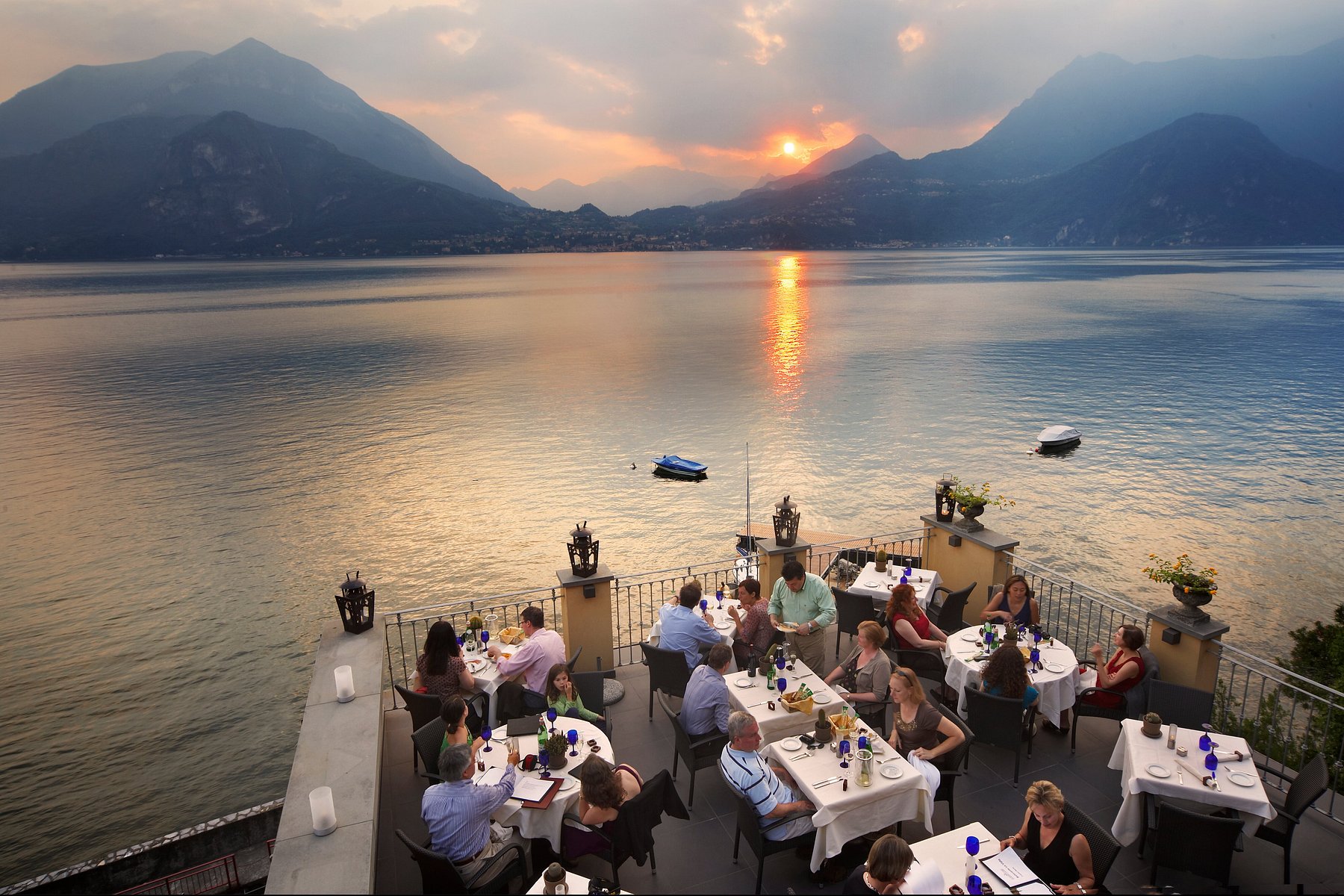 Cena in terrazza direttamente sul lago al tramonto, con montagne sullo sfondo