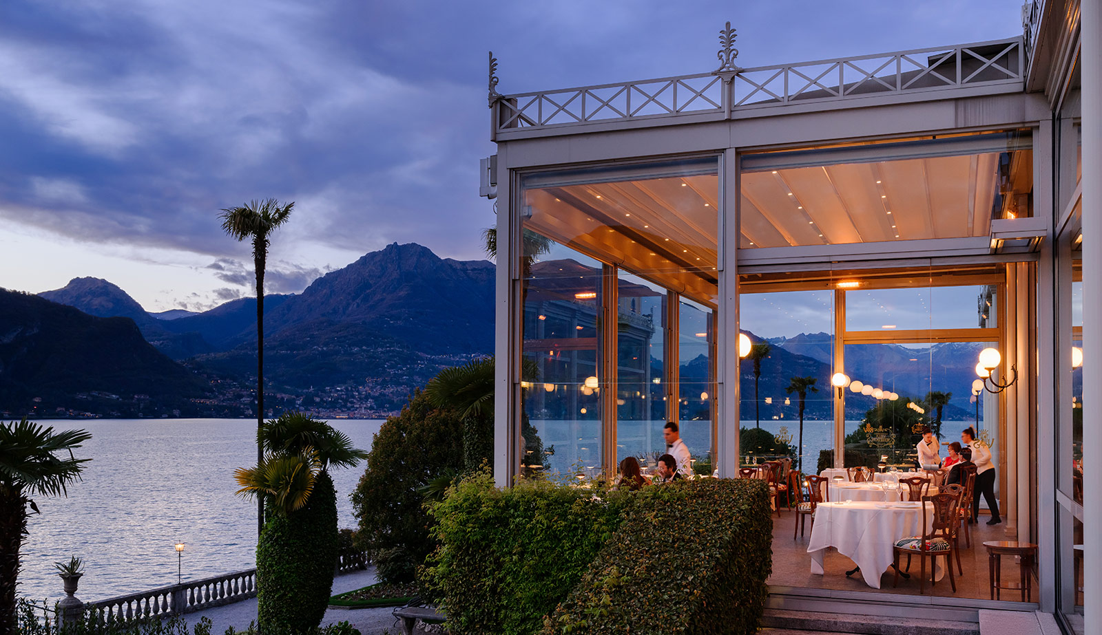 Ristorante panoramico con veranda e tavoli vista lago al tramonto